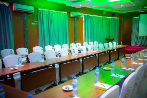 a meeting room with a long table and white chairs at Tiffany Diamond Hotels Ltd - Indira Gandhi street in Dar es Salaam