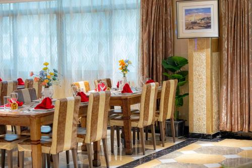 a dining room with a table and chairs at Tiffany Diamond Hotels Ltd - Indira Gandhi street in Dar es Salaam