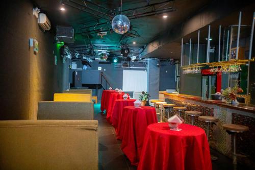 a row of tables with red table cloths in a restaurant at Tiffany Diamond Hotels Ltd - Indira Gandhi street in Dar es Salaam