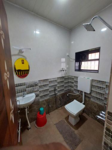 a bathroom with a white toilet and a sink at Vista Valley Home stay-Gokarna in Kumta