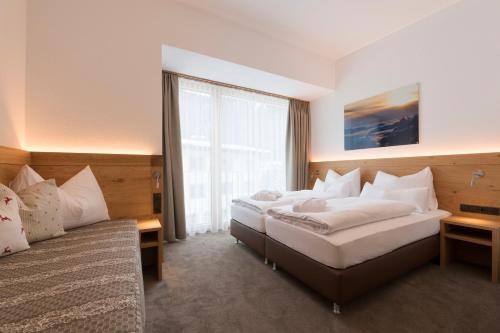 a hotel room with two beds and a window at Anthony's Peaks & Pillows in Sankt Anton am Arlberg