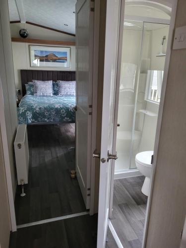 a bedroom with a bed and a toilet in a room at Elegant 2 Bedroom En-Suite Caravan with Bathtub near Edinburgh Seton Sands Holiday Village in Port Seton