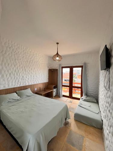a bedroom with a bed and a tv and a window at Aurora Beach in Trairi