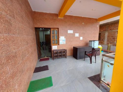 a room with a brick wall and a table and chair at Vista Valley Home stay-Gokarna in Kumta