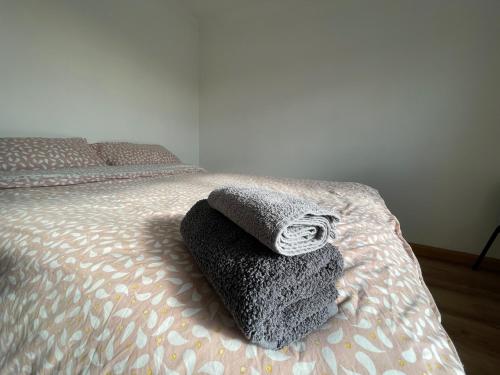 a bed with two towels sitting on top of it at 4-Bed Barnwell Retreat- Sleeps 9 Garden & Parking in Stevenage