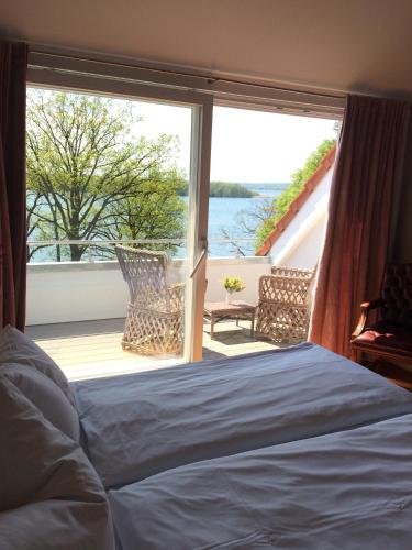 a bedroom with a bed and a large window at Seehotel Lichtenberg in Lichtenberg