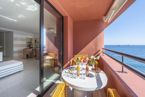 a balcony with a table and a view of the ocean at Monte-Carlo Beach in Roquebrune-Cap-Martin