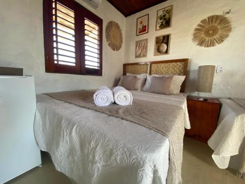 een slaapkamer met een bed met handdoeken erop bij Pousada Villa La Creta in Amontada