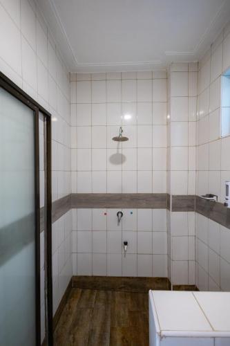 an empty bathroom with white tiled walls and a sink at The Safiya Hotel, Diani Beach in Diani Beach