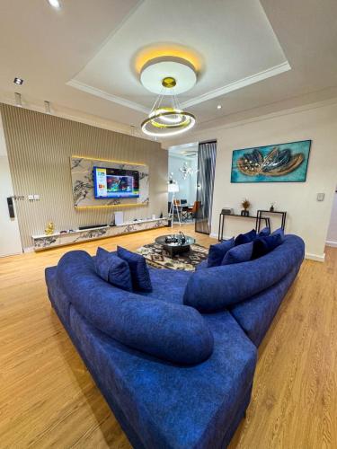 a large blue couch in a living room at Spacious 2bed apartment in Abuja
