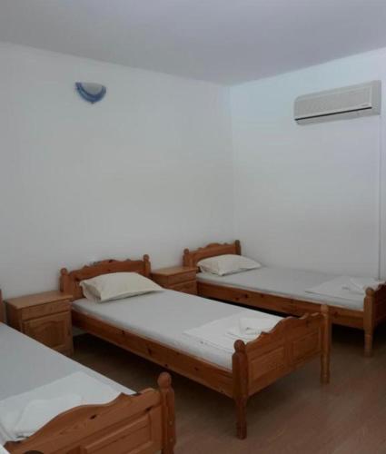 a group of four beds in a room at Семеен Хотел Сандим in Kŭrdzhali
