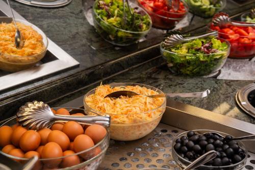 a buffet with bowls of food and bowls of vegetables at Verdi Budapest Aquincum in Budapest