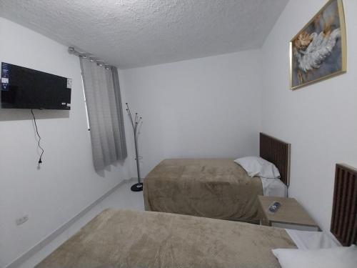 Una habitación de hotel con una cama y un televisor de pantalla plana. en Extraordinary Apartment, en Tacna