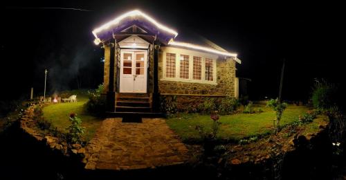 a small house with lights on it at night at Springdale Villa in Kodaikānāl