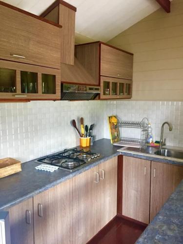 a kitchen with wooden cabinets and a stove top oven at Charming House in Albion with Shared Pool in Albion