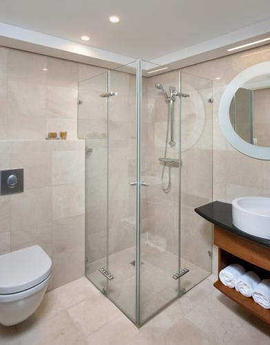 a bathroom with a shower and a toilet and a sink at The Inbal Jerusalem in Jerusalem