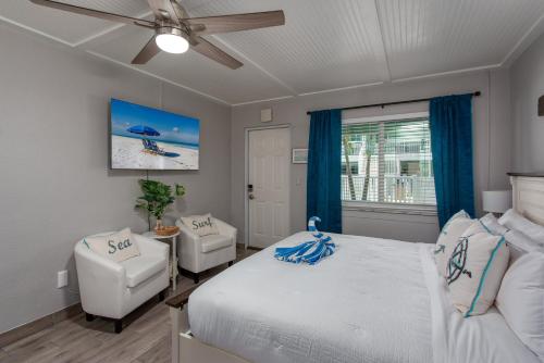 una camera da letto con un letto e un ventilatore a soffitto di Tropic Terrace Suite #9 - Beachfront Resort a St Pete Beach