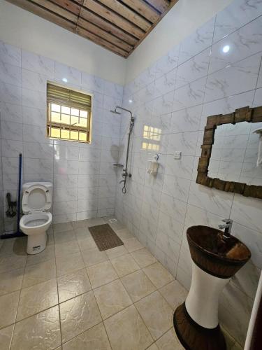 a bathroom with a toilet and a sink at Bugoma Palms Resort Sand Beach 