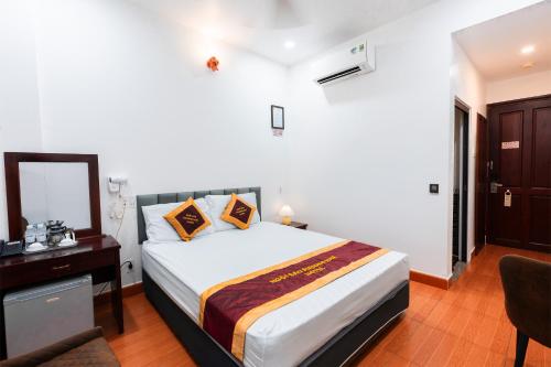 a bedroom with a bed and a desk and a mirror at Townhouse Oak Southern Star Hotel Quang Trung Industrial Zone District 12 in Ho Chi Minh City