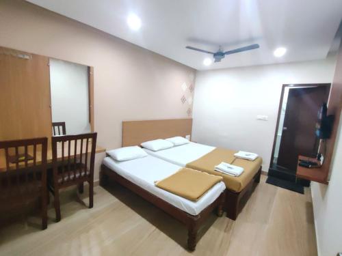 a small bedroom with a bed and a tv at Nandan Residency in Mysore