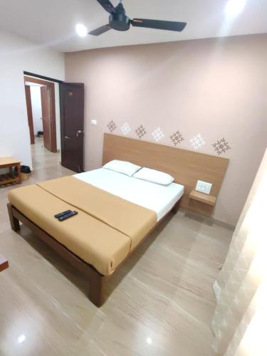 a bedroom with a bed with a ceiling fan at Nandan Residency in Mysore