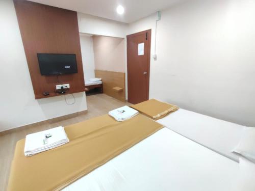 a hotel room with a bed and a tv at Nandan Residency in Mysore