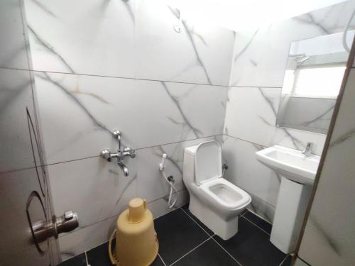 a bathroom with a toilet and a sink at Nandan Residency in Mysore
