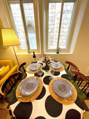 a dining room table with plates and wine glasses at Authentic apartments with jacuzzi and Two-level central Haifa in Haifa