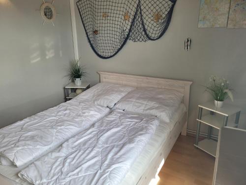 布特亚丁根Ferienhaus Klein的卧室内的白色床,有两棵植物