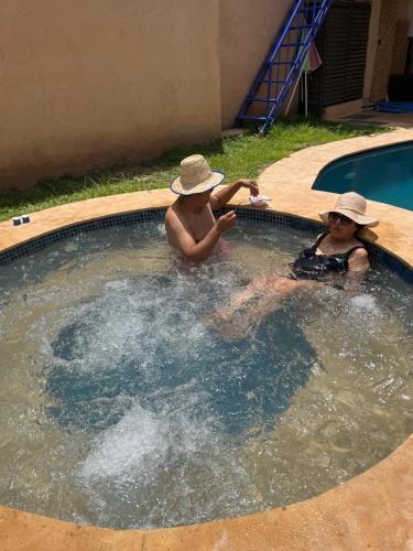two children are playing in a swimming pool at Dar NFis Suites et chambres de luxe dans un havre de paix vue paradisiaque au bord du lac in Lalla Takerkoust