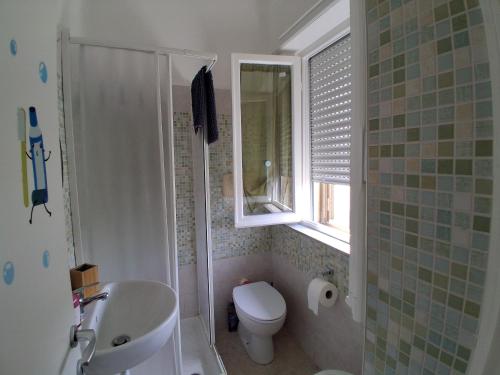 a bathroom with a sink and a toilet and a window at Casa vacanze La Giannina in Grosseto