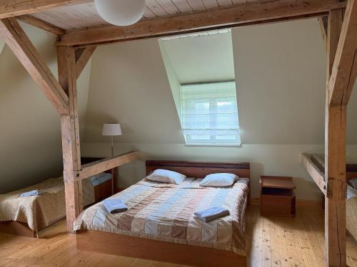 a bedroom with a bed and a large window at Atpūtas komplekss "Ratnieki" in Ratnieki