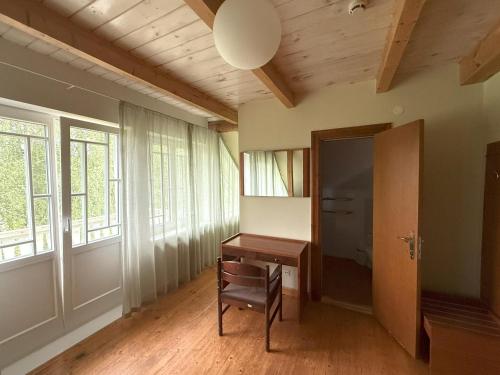 a room with a desk and a chair and windows at Atpūtas komplekss "Ratnieki" in Ratnieki