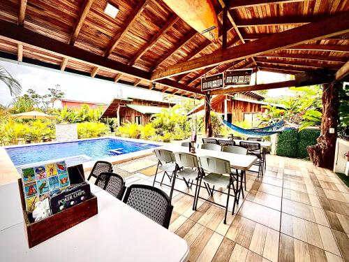 a patio with tables and chairs and a swimming pool at Cabañas Litos #3 in Fortuna