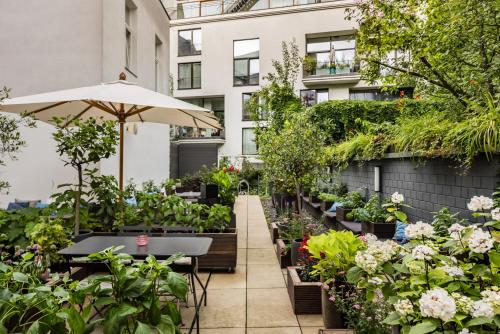 ベルリンにあるHotel AMANO Rooms & Apartmentsの植物と傘のある屋外庭園