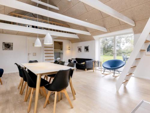 a dining room and living room with a table and chairs at 6 person holiday home in Løkken in Løkken