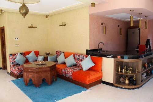 a living room with a couch and a table at Dar NFis Suites et chambres de luxe dans un havre de paix vue paradisiaque au bord du lac in Lalla Takerkoust
