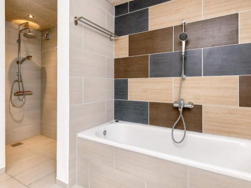 a bathroom with a tub and a shower at 6 person holiday home in Løkken in Løkken