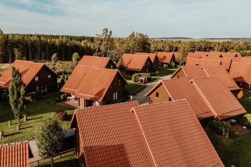 une vue aérienne sur une rangée de maisons au toit rouge dans l'établissement Naturerlebnisdorf Blauvogel Hasselfelde, à Hasselfelde