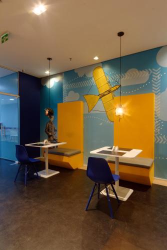 a room with two tables and a plane on the wall at Golden Tower Express Anhembi by Fênix Hotéis in Sao Paulo