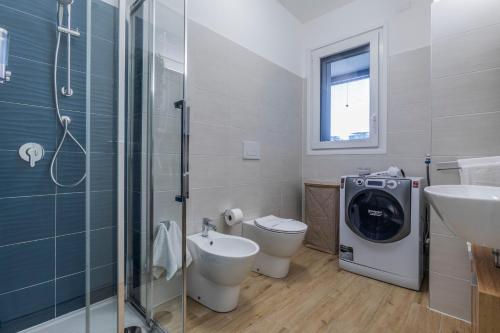 a bathroom with a toilet sink and a washing machine at Prime Living Milano Merlata - Balcony Apartment in Milan