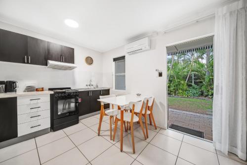 a kitchen with a table and chairs and a window at Beachcomber Peregian Beach in Peregian Beach