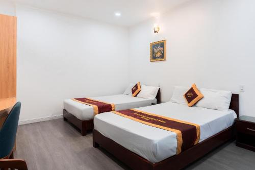 una habitación de hotel con dos camas y una silla en Dancenter District 12 Near Quang Trung Exhibition Center Formerly Southern Star Hotel, en Ho Chi Minh