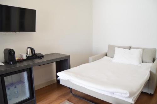 a room with a bed with a television and a desk at niXie Hotel Bodrum in Bodrum City
