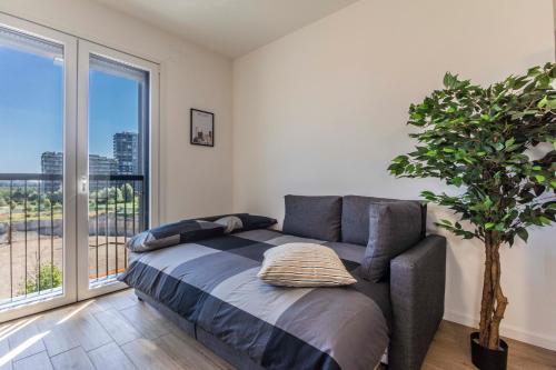 a bedroom with a couch and a large window at Prime Living Milano Merlata - Balcony Apartment in Milan