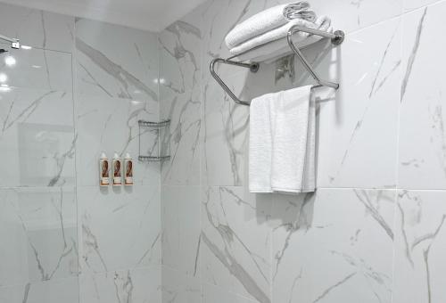 a bathroom with a shower with white marble walls at niXie Hotel Bodrum in Bodrum City