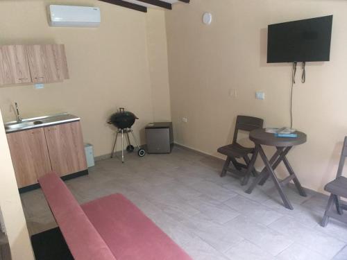a living room with a table and a television at Finca el porvenir cabañas viviendas turísticas in Cisneros