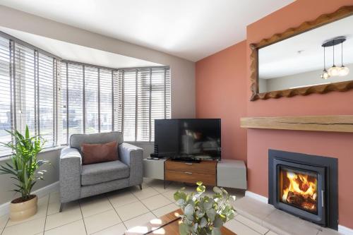 a living room with a fireplace and a television at 4 Bedroom Home with Hot Tub near Gloucester City in Gloucester