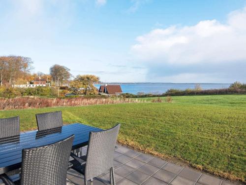einen blauen Tisch mit Stühlen und Blick auf das Wasser in der Unterkunft Seaside Luxury Retreat - By Traum Ferienwohnungen in Haderslev