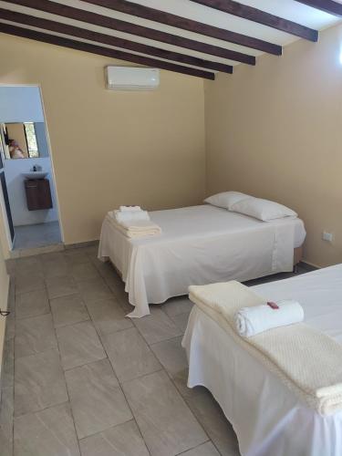 a room with two beds and two chairs in it at Finca el porvenir cabañas viviendas turísticas in Cisneros